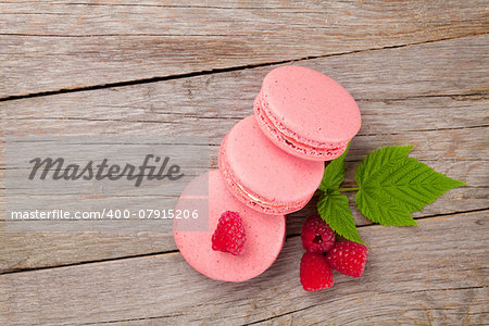 Pink raspberry macaron cookies on wooden table background