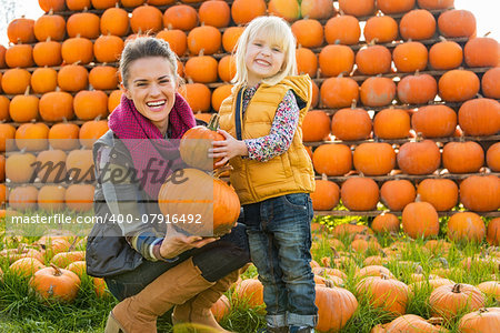 Portrait of happy mother and child choosing pumpkins
