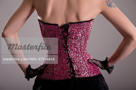 Rear view of elegant woman wearing purple corset with floral pattern