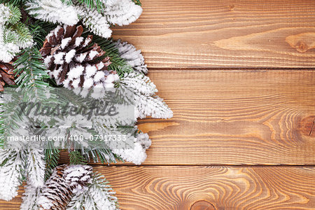 Christmas fir tree with snow on rustic wooden board with copy space