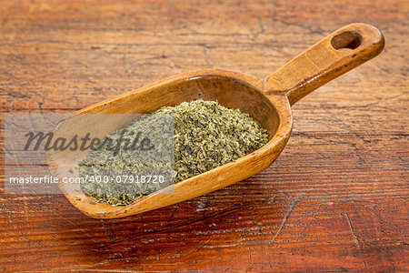 sea lettuce flakes on a rustic wooden scoop against grunge wood