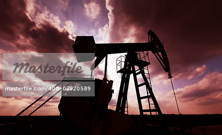 Oil and gas well profiled on sunset