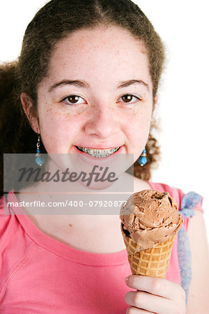 Portrait of cute Latina girl with curly hair and braces holding a yummy chocolate icre cream cone.  White background.