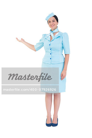 Pretty air hostess showing with hand on white background