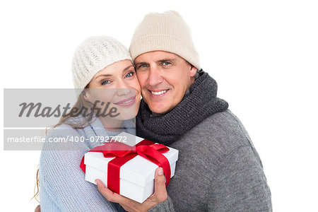 Casual couple in warm clothing holding gift on white background