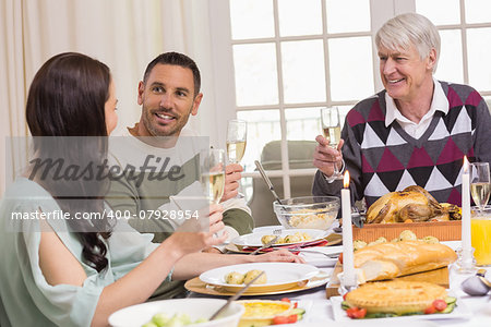 Smiling family toasting during christmas dinner at home in the living room