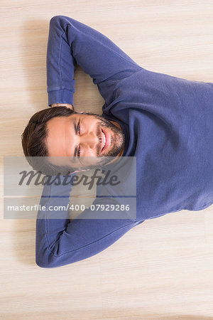 Happy man lying on floor at home in the living room