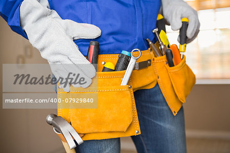 Close up of handyman in tool belt in a new house