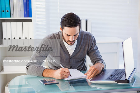 Focused casual businessman working at his desk in the office