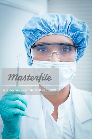 Portrait of female dentist wearing surgical mask and safety glasses