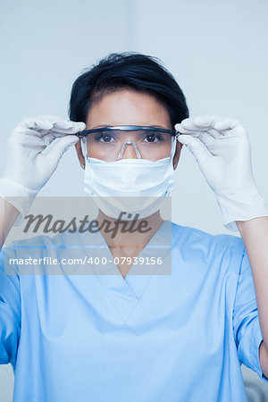 Portrait of female dentist wearing surgical mask and safety glasses