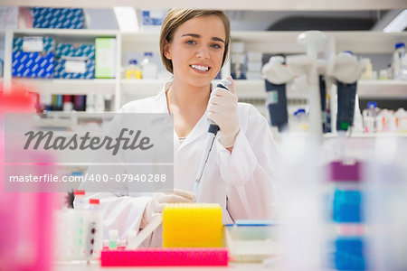 Pretty science student using pipette at the university