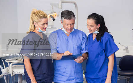 Smiling co-workers talking about a x-ray in dental clinic