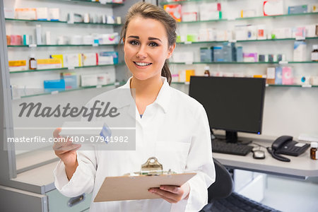 Junior pharmacist holding medicine box at the hospital pharmacy