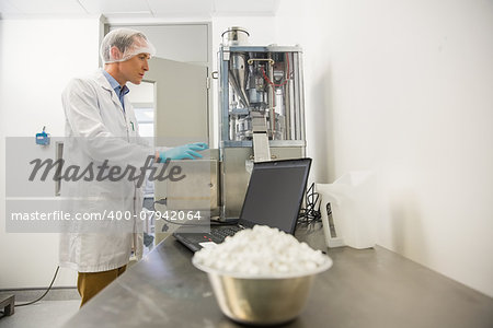 Pharmacist using heavy machinery to make medicine at the laboratory