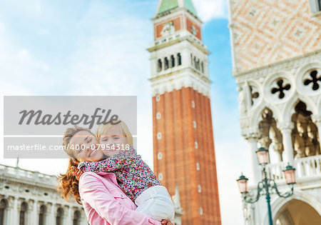 Portrait of happy mother and baby against campanile di san marco in venice, italy