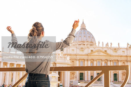 Young woman rejoicing in front of basilica di san pietro in vatican city state