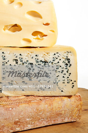 Three various big cheese pieces arranged on each other. Cheese background.