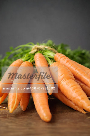 A bunch of fresh carrots on wooden table