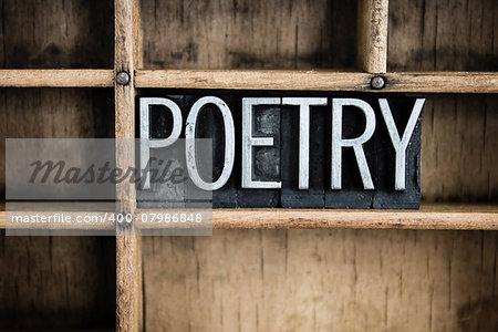 The word "POETRY" written in vintage metal letterpress type in a wooden drawer with dividers.