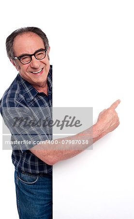 Causal matured man pointing finger at placard isolated over white background