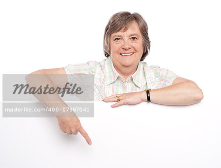 Closeup of an attractive old woman indicating towards billboard