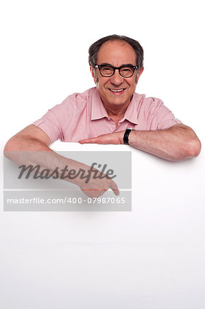 Happy old man pointing at blank billboard isolated over white