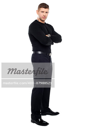 Handsome young bodyguard, full length portrait. Arms folded