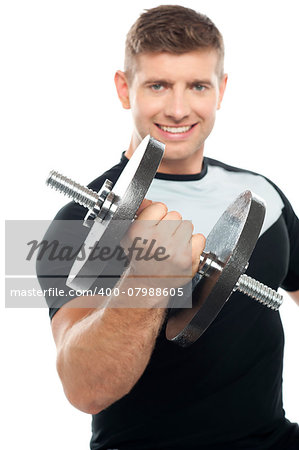 Cheerful young gym instructor posing with heavy dumbbell over white background