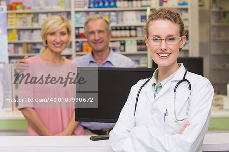 Pharmacist and costumers smiling at camera at pharmacy
