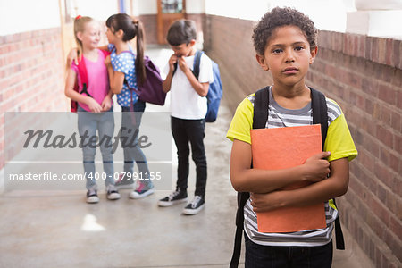 Pupils friends teasing a pupil alone in elementary school