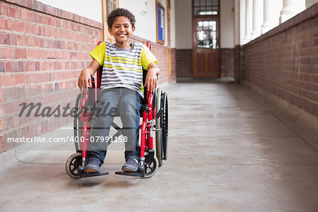 Cute disabled pupil smiling at camera in hall at the elementary school