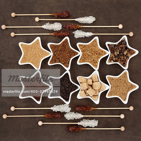 Brown and white sugar selection with crystal lollipops in abstract design over brown paper background.