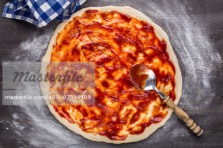 Making of pizza. Tomato sauce on a dough