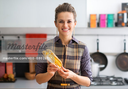 Portrait of happy young housewife with corn