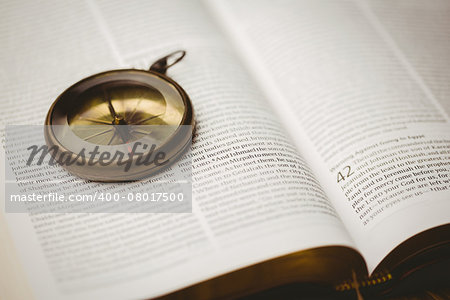 Close up of compass on open bible