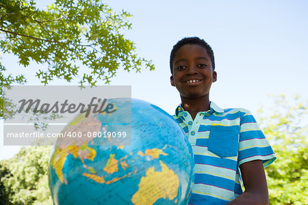 Cute little boy with globe on a sunny day