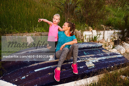 Healthy mother and baby girl pointing while outdoors in the evening