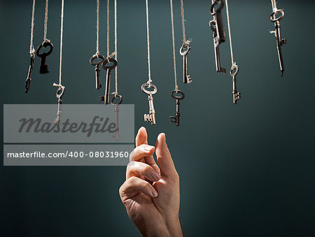 Hand choosing a hanging key amongst other ones.