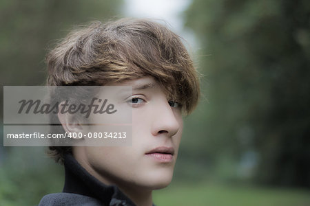 moody looking young man in outdoor setting