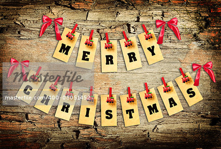 Merry Christmas lettering with clothes-peg in shape of train on old wooden background