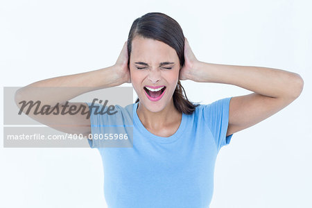 Screaming woman covering her ears on white background