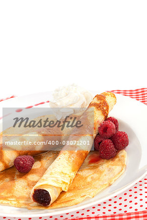 Delicious pancakes with raspberries and cream on plate isolated on white. Traditional sweet dessert in red and white. Culinary eating.