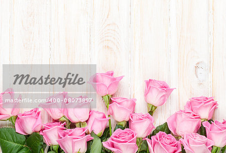 Pink roses bouquet over wooden table. Top view with copy space