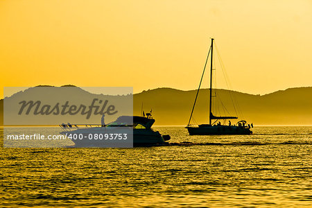 Yacht and sailboat silhouette at golden sunset view