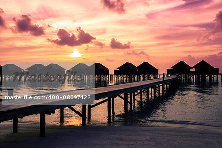 Maldives  sunset with water villas silhouette