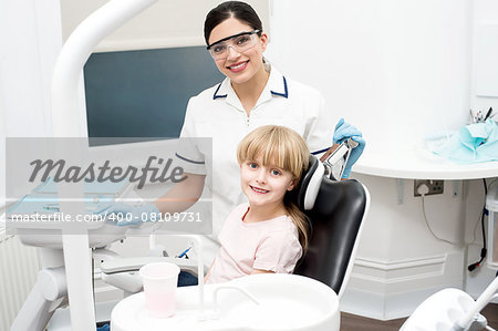 Smiling dentist with little girl after her check up