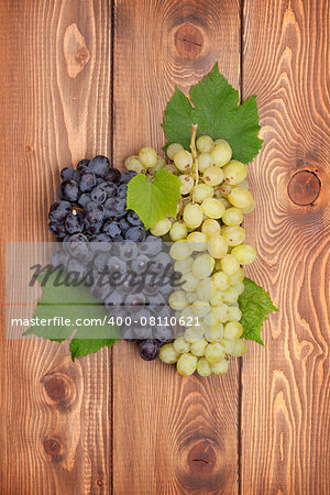 Bunch of red and white grapes on wooden table background