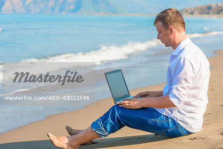 Free businessman working on a sandy beach