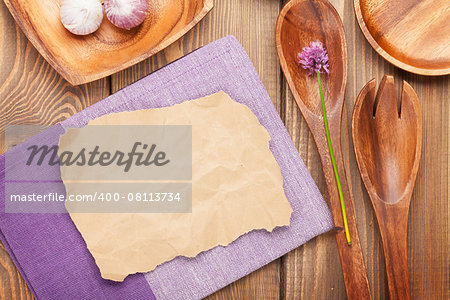 Wood kitchen utensils over wooden table background with paper for copy space